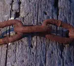 Rusty Chain Wrapped Around a Weathered Log