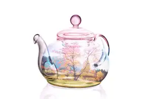 Double exposure of a clear glass teapot overlaid with a spring meadow and blossoming trees.